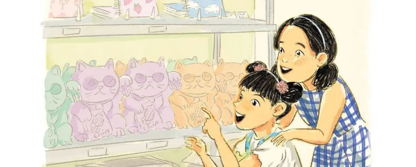 Two girls admiring colorful cat figurines.